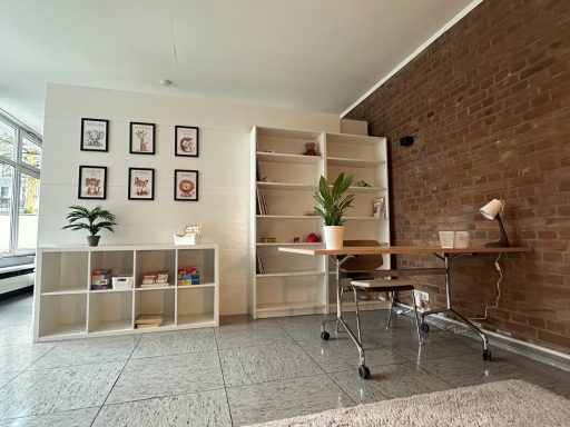 Helles Arbeitszimmer mit Regal, Schreibtisch und Pflanzen, Wänden aus Ziegeln.